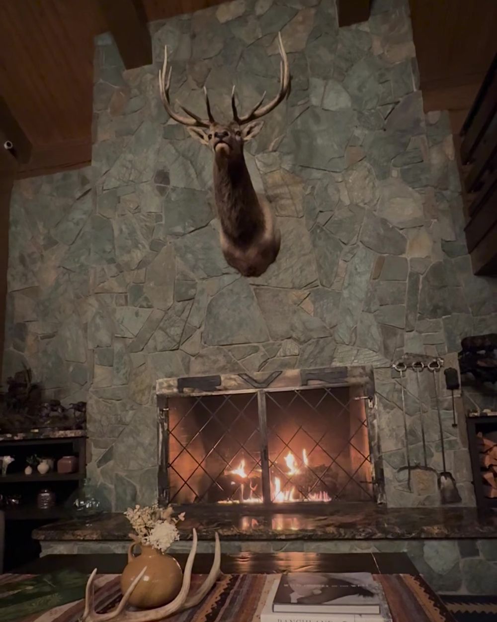 Stone fireplace with an elk mount in the main lodge